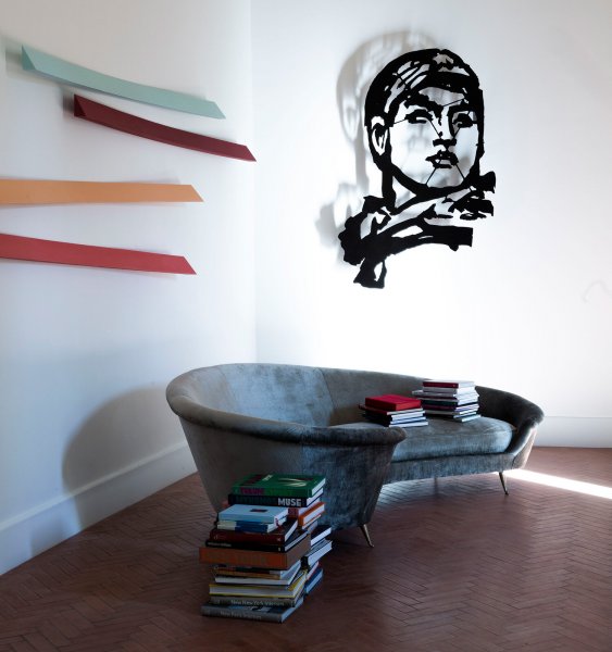 Über der geschwungenen Couch in einem der Salons hängt der Laserstahlschnitt Head (Model Opera) Variation von 2017 des südafrikanischen Künstlers William Kentridge. Die farbigen Holzstreifen Cangiante 5 aus dem Jahr 2020 sind von Giuliano Dal Molin.