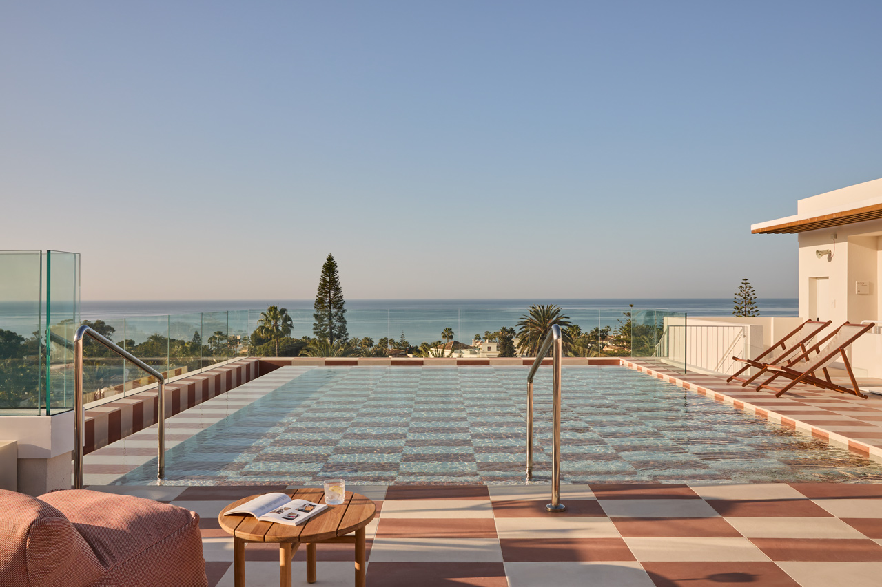 Pool mit Blick auf Palmen und Meer.